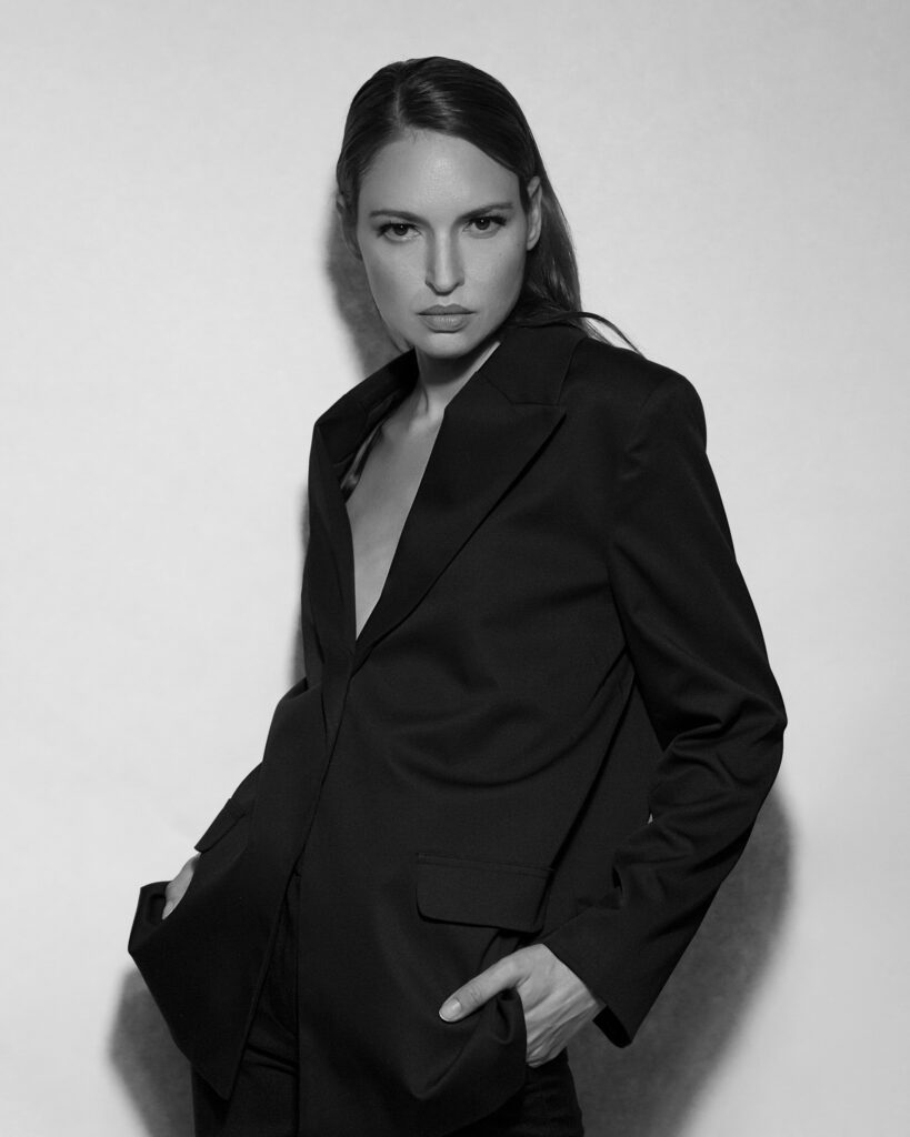 Model Bibi Alfonso posing in a black blazer in a black-and-white portrait.