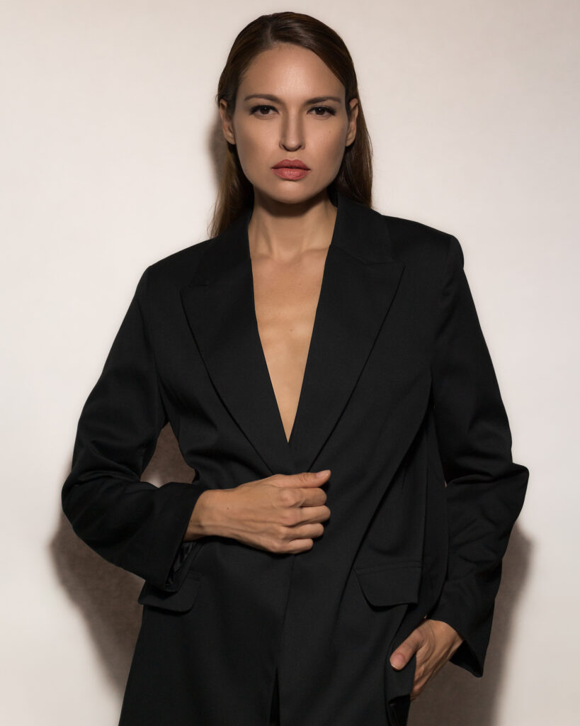 Model Bibi Alfonso posing in an oversized black blazer against a light background.